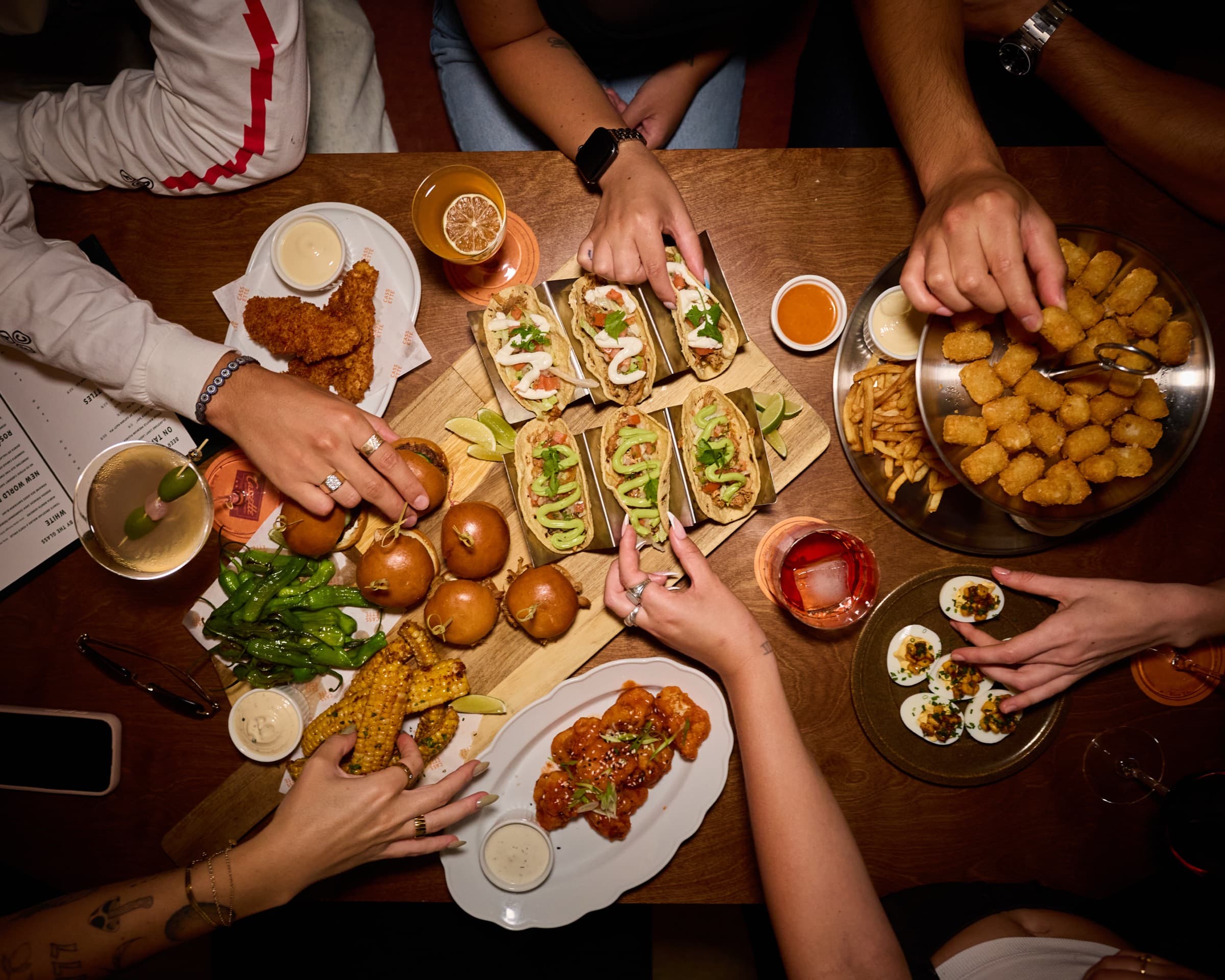 A long table of friends sharing plates at Cassette